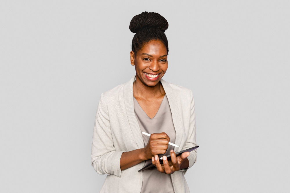 A smiling woman writing notes on a tablet digital device